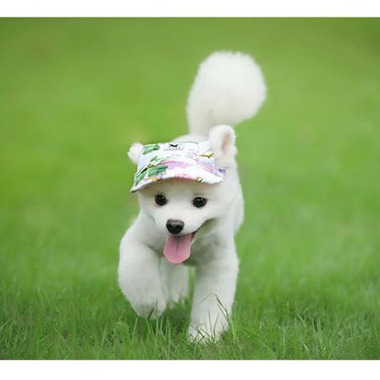 Casquette pour chien Nelly sur un chiot blanc courant dans l’herbe, museau heureux et langue pendante.